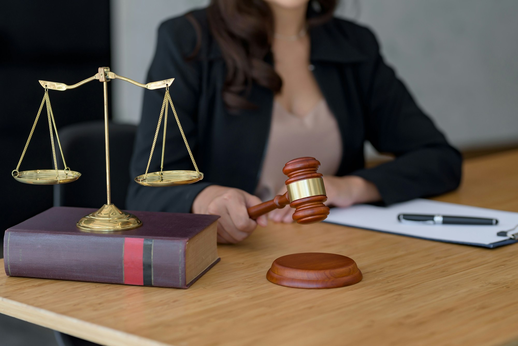 Businesswoman or lawyer woman hands knocking hammer judge scales and paper at office